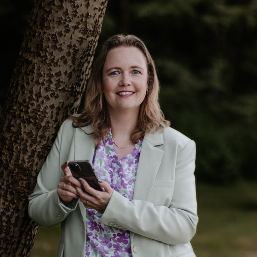 Bies Support Marjon staat tegen een boom met haar telefoon in haar hand
